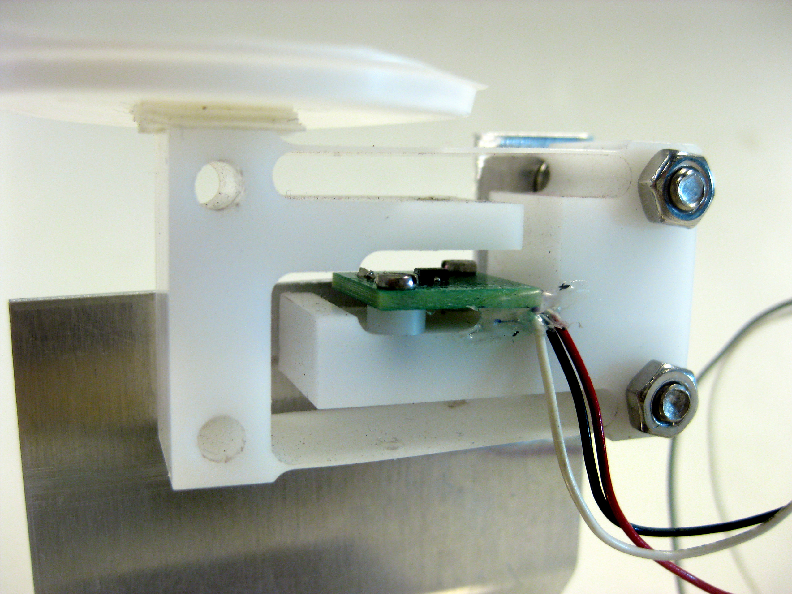 CNC - gefreesd prototype van een gewichtssensor uit POM met geïntegreerde parallelle bladveer - constructie. Analoge hall sensor met enkele magneet en beperkte uitslag.